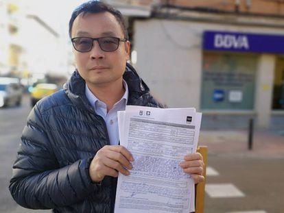 Enguan Chen muestra su hoja de reclamación ante la sucursal del BBVA en Usera.