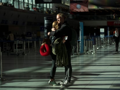 Una pareja se abraza en el aeropuerto internacional de Ezeiza, en Buenos Aires, antes de embarcar hacia Alemania, el 23 de marzo.