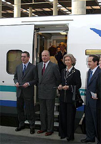 Los Reyes, acompañados de Lucas y de Ruiz-Gallardón, posan ante la puerta del tren en la estación de Atocha.