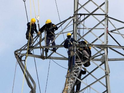 Varios operarios reparan una torre de tendido eléctrico en Girona.