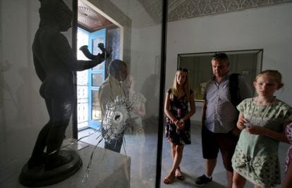 Una familia contempla, este martes en el Museo Nacional del Bardo, una obra tiroteada durante el atentado islamista del pasado marzo.