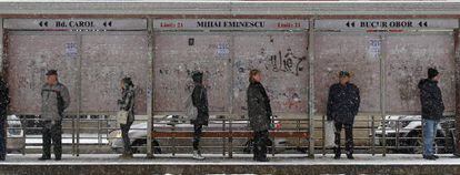 Ciudadanos rumanos esperan el autob&uacute;s bajo la nieve en Bucarest, el lunes.