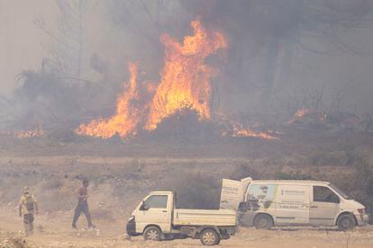  Los voluntarios luchan contra el fuego después de que los fuertes vientos siguieran avivando los incendios forestales en Rodas.
