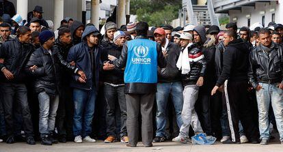 Un trabajador de el Alto Comisionado de las Naciones Unidas habla con un grupo de inmigrantes llegados desde Túnez a la isla Lampedusa, Italia.