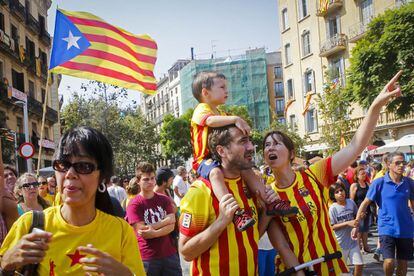 Una familia camina entre la multitud concentrada en las calles de Barcelona con motivo de la Diada.