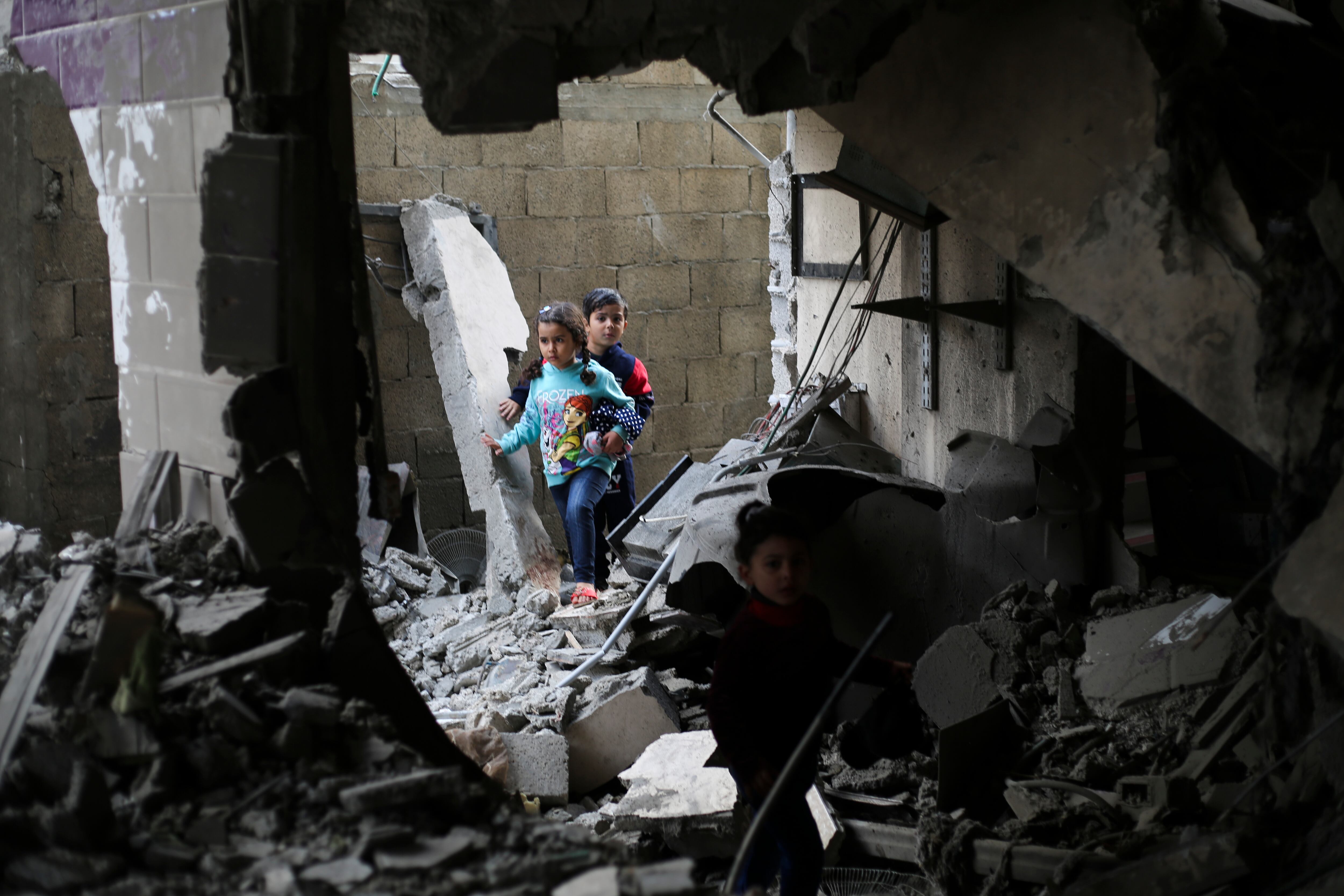 Niños palestinos caminan entre escombros en Rafah este jueves.