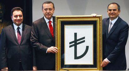 El primer ministro de Turqu&iacute;a, Recep Tayyip Erdogan (en el centro), con la nueva imagen de la lira y flanqueado por su segundo, Ali Babacan (derecha) y el gobernador del Banco Central Erdem Basci,