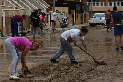 Vecinos de Redován limpia una calle de barro tras las lluvias de Redován (Alicante), este jueves.