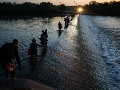Un grupo de migrantes haitianos cruzan el Río Bravo para obtener alimentos y suministros cerca del puerto de entrada Del Río-Acuña en Ciudad Acuña, estado de Coahuila, México.