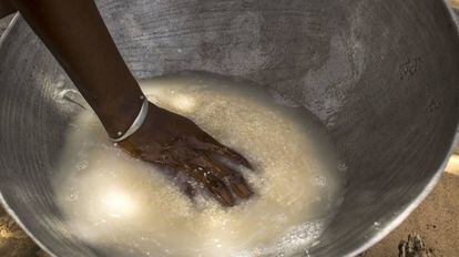 Una mujer prepara arroz en una palangana con agua, en Senegal.