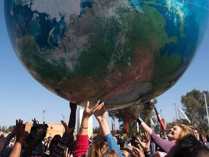 Asistentes a la COP22 juegan con un globo gigante que representa al planeta Tierra en Marrakech.