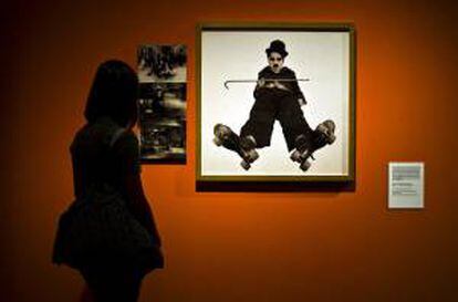 Una mujer observa una de las fotografías de "Chaplin en imágenes", en una exposición sobre la vida del popular cómico londinense. EFE/Archivo