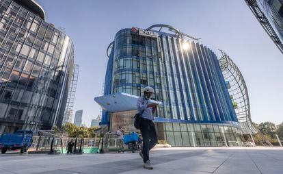 Un hombre camina junto a la sede de Evergrande en Shanghai, este jueves.