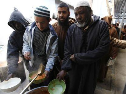 Presos de un centro de detención de Misrata hacen cola para recibir su ración de comida.