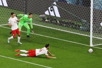 Wojciech Szczensy (segundo por la izquierda), y los jugadores Jakub Kiwior (a la izquierda) y Bartosz Bereszynski miran la pelota tras una jugada.