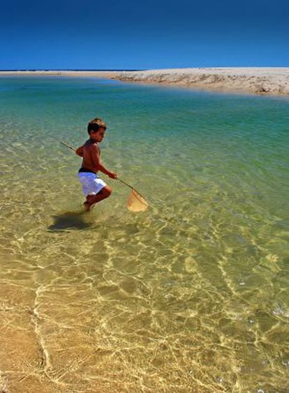 Un niño pesca en la playa Cacela Velha, en Portugal.