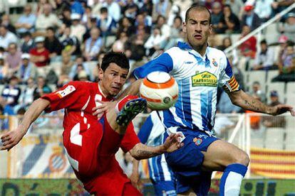 El delantero serbio del Atlético de Madrid Kezman chuta el balón en presencia del defensa del Espanyol Alberto Lopo.