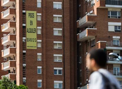 Un joven ante un edificio de pisos de alquiler de Barcelona, en una imagen de archivo.