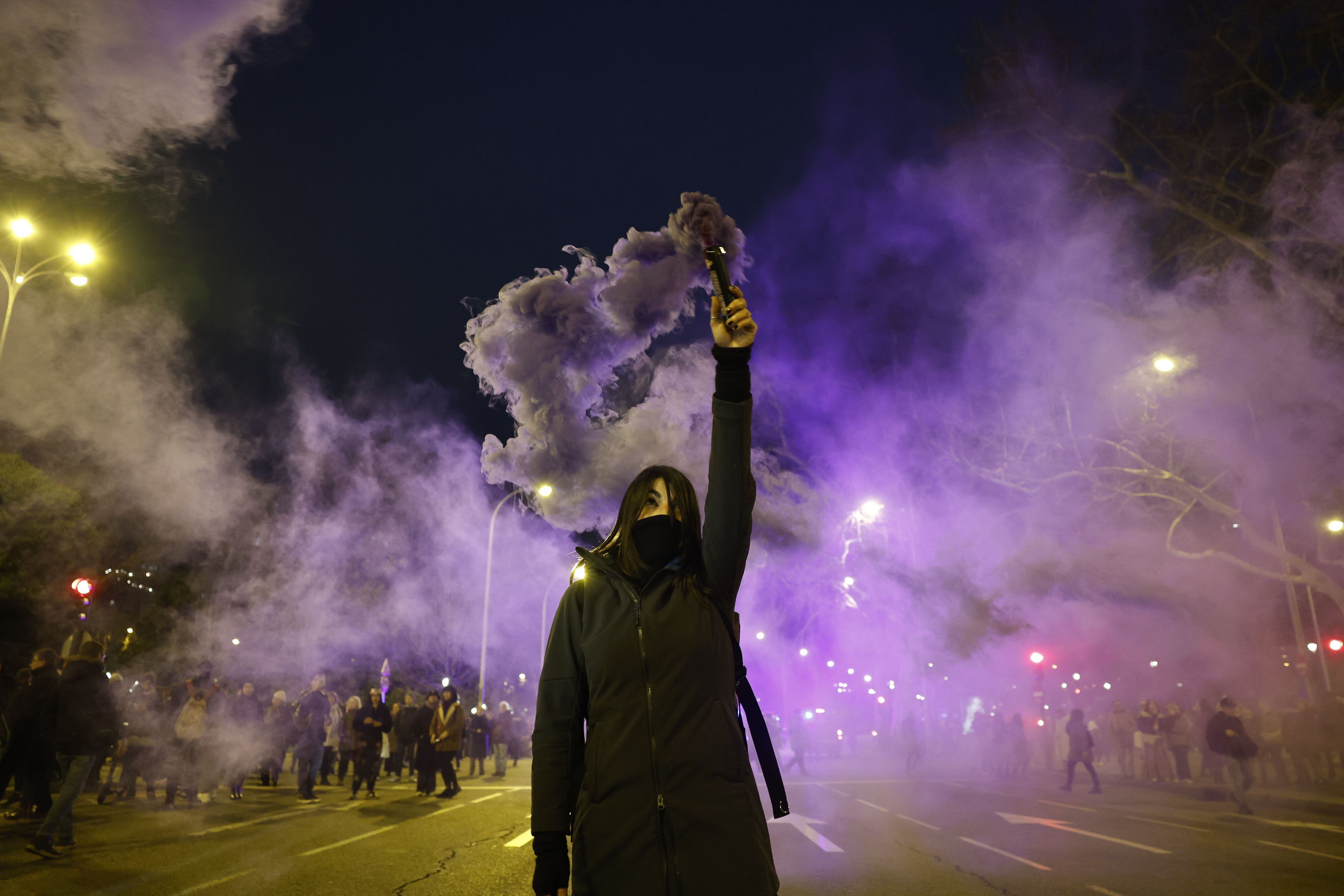 Una mujer sostiene un bote de humo en el paseo de Recoletos de Madrid, durante la manifestación transinclusiva.