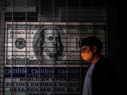 Una persona camina frente a una casa de cambio de divisas, en Buenos Aires.
