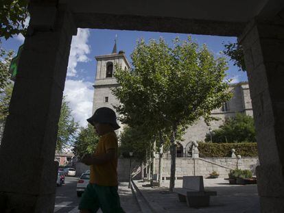 Un niño pasa por delante de la parroquia de la Asunción, en Valdemorillo.