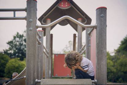 Un niño llora en un columpio. 