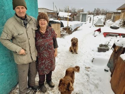 Gregori y Liudmila Vovk, junto al módulo en el que viven en el municipio ucranio de Zagaltsi, el lunes. Detrás, cubierto de nieve, lo que queda su antigua casa destruida.