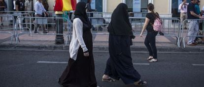 Mujeres musulmanas caminan por la Avenida Rey Juan Carlos I de Melilla, al acabar un desfile militar el pasado junio.