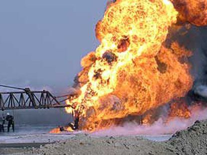 Un grupo de bomberos intenta apagar un incendio en un pozo petrolero iraquí.