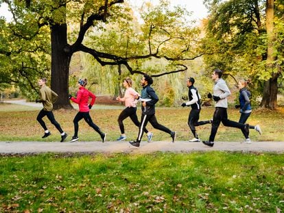 Un grupo de corredores hace deporte alrededor de un parque.
