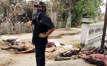 Un funcionario gubernamental, junto a cadáveres de varios inmigrantes madureses, algunos de ellos decapitados, ayer en Sampit, en la isla de Borneo.