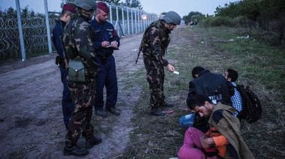 Policies i soldats comproven la documentació de diversos refugiats a la frontera entre Sèrbia i Hongria, el 15 de setembre del 2015.