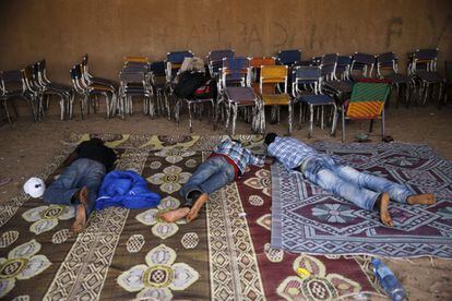 Tres migrantess de Benín duermen sobre unas alfombras en Agadez mientras esperan a que haya algún vehículo disponible para empezar su viaje a través del desierto con destino a Libia.