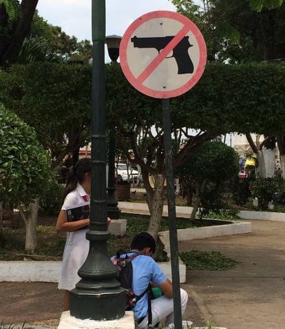 Señal de prohibido llevar armas en el parque de la catedral de Santa Ana.