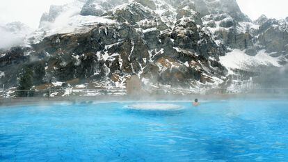 Piscina exterior del balneario Walliser Alpentherme Burgerbad & Spa Leukerbad, en Suiza, con la montaña Gemmi como telon de fondo.