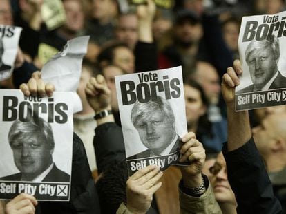 Aficionados del Manchester United muestran carteles de Boris Johnson, en el estadio de Anfield.