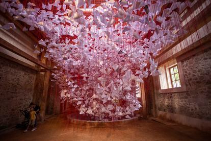 Dos visitantes contemplan la obra 'Tell Me Your Story' (cuéntame tu historia), una intervención del artista japonés Chiharu Shiota en el Gran Hammam de Pristina (Kosovo).