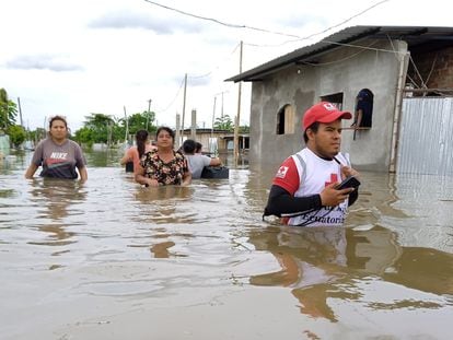 Vecinas y personal de la Cruz Roja caminan por una calle inundada en Guayas (Ecuador), el pasado 11 de marzo.
