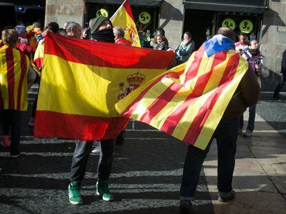 Un ciutadà amb una bandera estelada penjada al coll creua la plaça Sant Jaume, a Barcelona, amb banderes espanyoles el 6 de desembre.