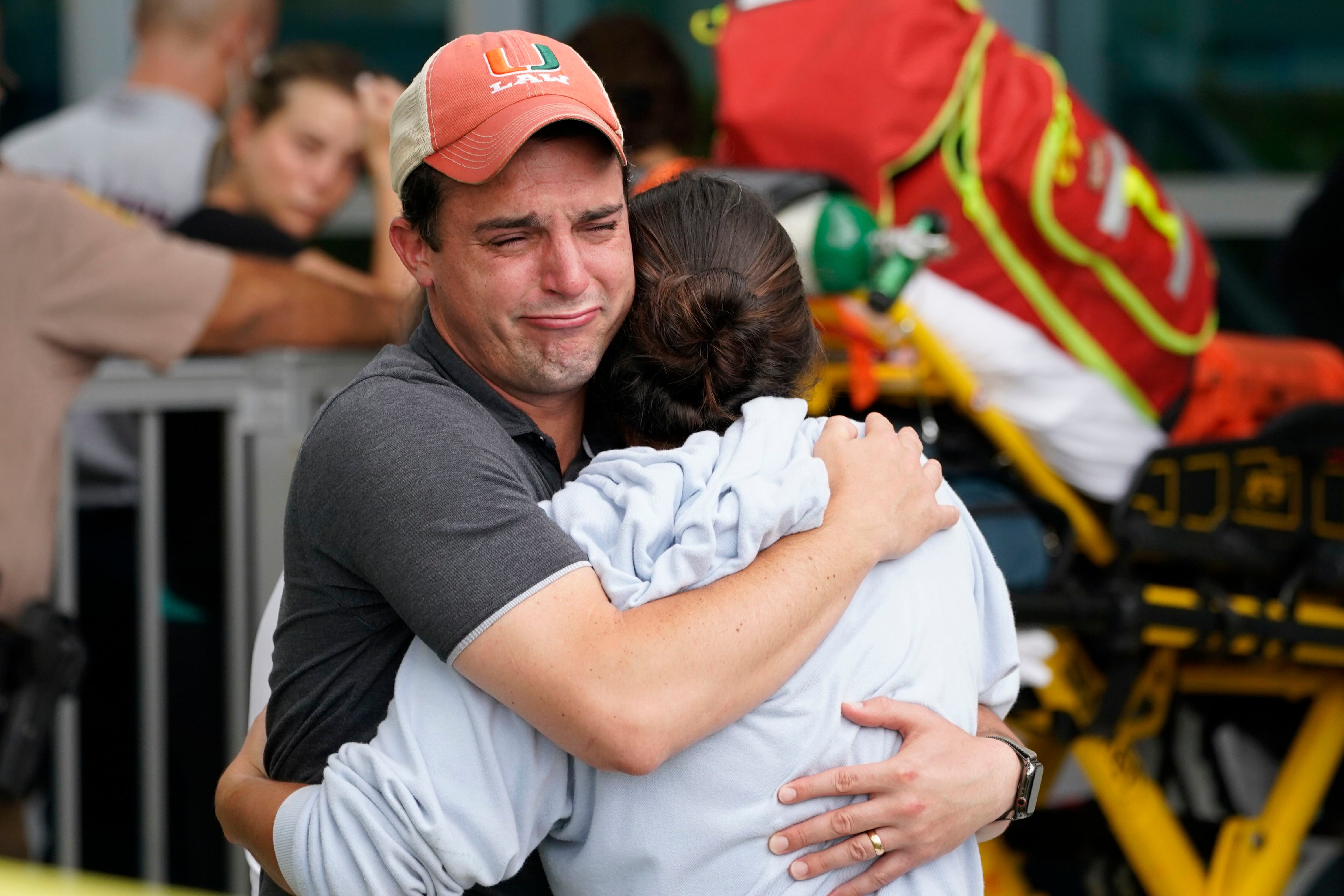 Una pareja se abraza tras el colapso del edificio en Surfside.