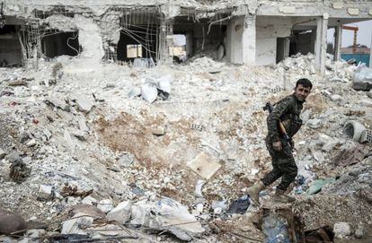 Un combatiente kurdo camina entre los escombros de un edificio en el centro de la ciudad siria de Kobane, este miércoles.