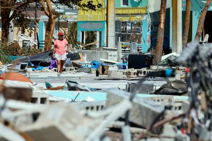 Una mujer camina por lo que queda de la zona de Times Square cerca del muelle Lynn Hall en la isla de Fort Myers Beach, este viernes.