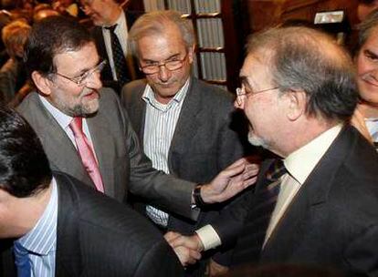 El líder del PP, Mariano Rajoy, saluda al vicepresidente Pedro Solbes al término del pleno del Congreso.