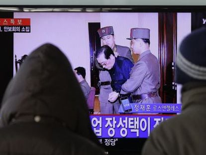 Dos surcoreanos ven por televisi&oacute;n la noticia, en Se&uacute;l.