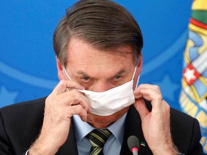 El presidente Bolsonaro se ajusta la mascarilla, este miércoles en Brasilia.