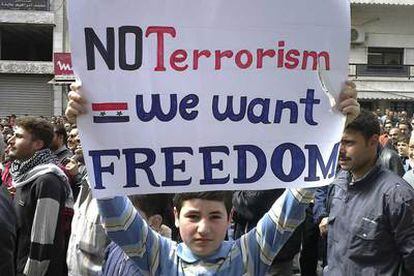 Un joven manifestante sostiene una pancarta en Damasco