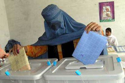 Una mujer cubierta con el burka deposita su voto en un colegio electoral de Jalalabad.