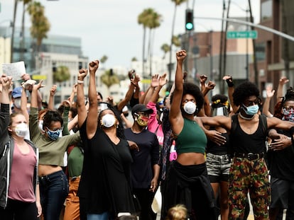 Manfiestantes del movimiento Black Lives Matter alzan el puño en Beverly Hills, California.