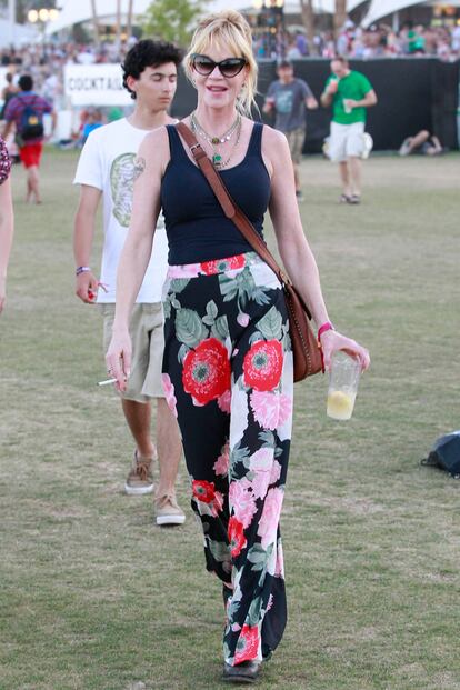 Melanie Griffitn con espíritu festivalero y pantalones de estampado floral.