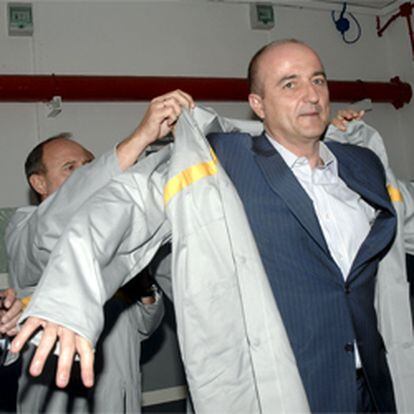 El ministro Sebastián se pone una bata de Renault durante su visita a la factoría de Renault en Valladolid, donde ha presentado el Plan Vive.